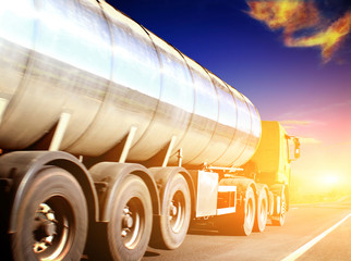 truck on blurry asphalt road under blue sky and sunset light