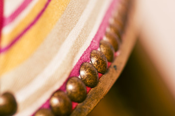 closeup of upholstery tacks on an old traditional wooden chair