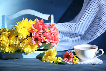 Beautiful flowers in basket, on dark wooden background