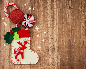 Christmas decorations and sock on wood background.