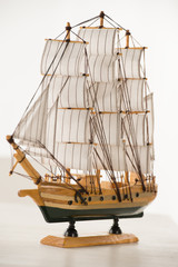 Wooden ship toy model on white table against white background