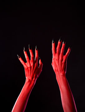 Red spooky devil hands with black nails, real body-art