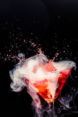 Fototapeta na wymiar red cocktail with splash and ice vapor