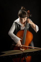 Girl with cello on black background