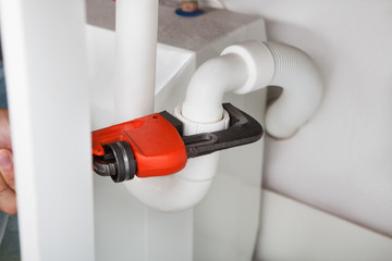 Plumber Fixing Sink In Kitchen