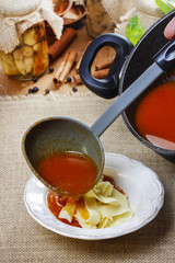 Serving tomato soup. Pouring soup into a plate