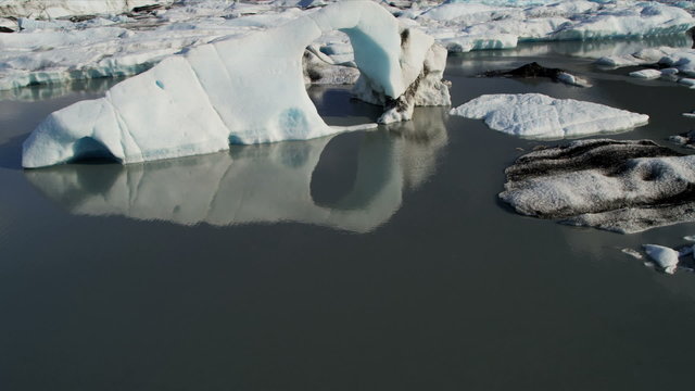 Aerial low view broken off icebergs dirt and debris, Alaska