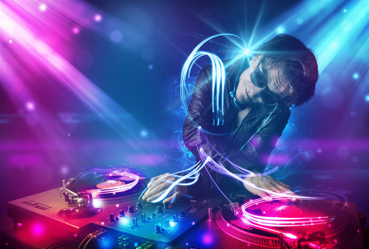 Energetic Dj mixing music with powerful light effects