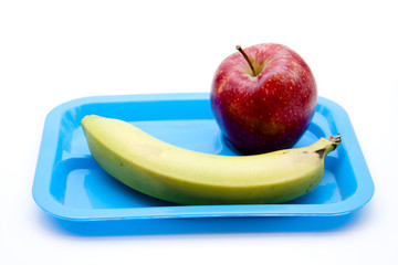Roter Apfel und Banane auf blauen Kinderteller
