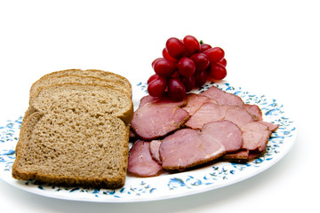 Toastbrot mit Rinderschinken und Trauben auf Teller