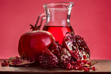 pomegranate isolated on a white with juice in the jug