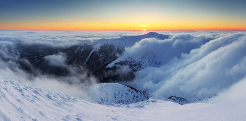 Winter sunset over the clouds with sun.