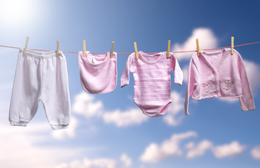 Clean baby girl clothes on the outdoor clothesline.
