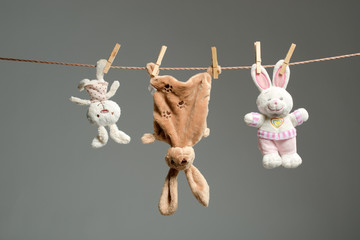 Plush bunnies on the clothesline,on  gray  background - 58200928