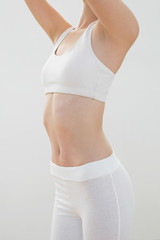 Fototapeta na wymiar Mid section of slender young woman in sportswear raising her arm
