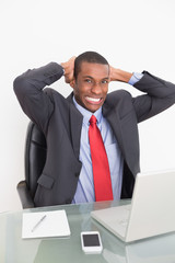 Elegant young Afro businessman with laptop at desk