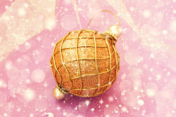 golden christmas ball on a pale pink background