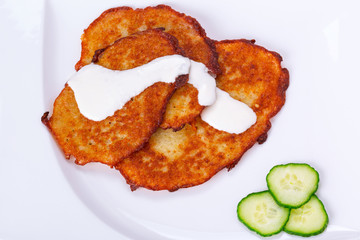 Potato pancakes with sour cream on the plate