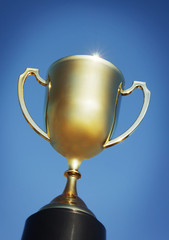 Gold trophy cup against blue