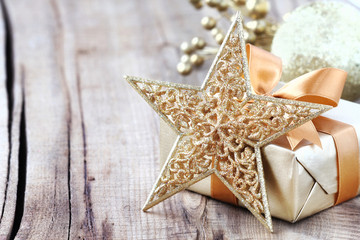 Shiny golden Christmas star and a gift with copy space
