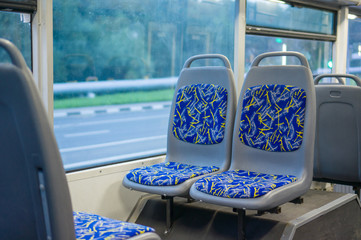 Blue seat places in modern city trolley bus on back side - Powered by Adobe