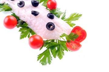 cod steak with tomatoes olives and parsley isolated on white