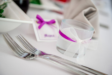 Wedding table decoration. Close-up forks and candle glass