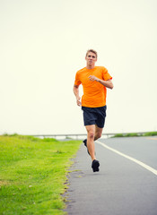 Fototapeta na wymiar Athletic man running outside, training outdoors. Jogging on road