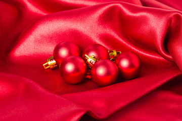 Red christmas balls on a red silk cloth