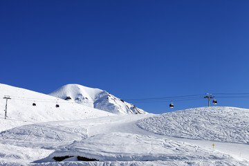 Fototapeta na wymiar Gondola lift and ski slope at nice day