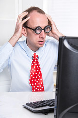 Mann mit Krawatte und Brille schockiert im Büro