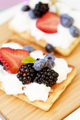 Waffles and fresh seasonal fruits with whipped cream