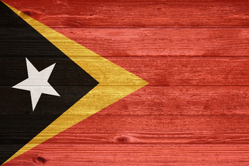 East Timor Flag painted on old wood plank background.