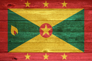 Grenada Flag painted on old wood plank background.