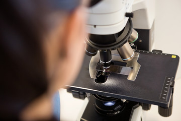 Scientist Using Microscope In Laboratory