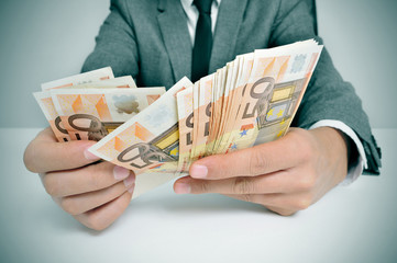 man in suit with counting euro bills