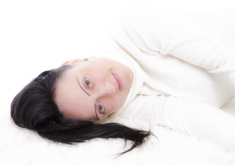 Obraz premium Pretty smiling woman lying on carpet floor