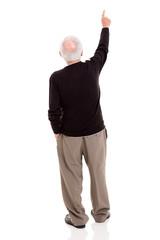 rear view of old man pointing at copy space