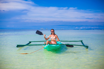 Little cute girl kayaking in the clear blue sea