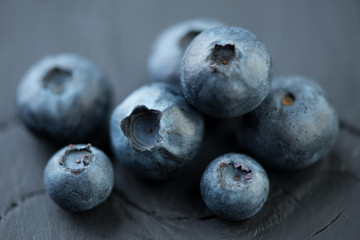 Ripe blueberries over black wooden background