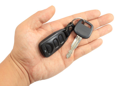 Hand holding car keys isolated on white
