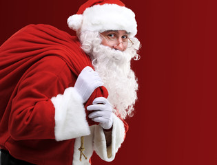 Portrait of Santa Claus carrying huge red sack with presents