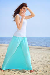 young woman on seacoast with shell in hand