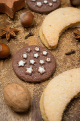Christmas cookies, spices, sugar and nuts on a wooden background