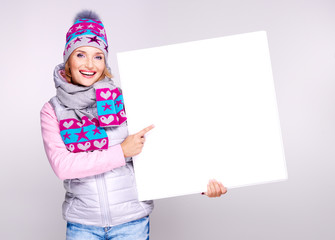 Adult smiling  woman in winter hat holds the white banner