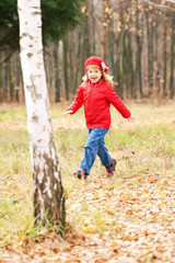 Happy smiling little girl running in forest