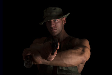 Soldier holding gun and flashlight.