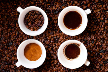 Four different mugs of coffee, ground, coffee beans