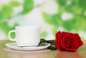 Cup of coffee with a red rose