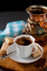 Cup of coffee with cookies on wooden board